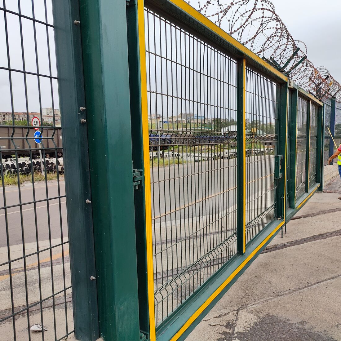 Portão de correr em rede soldada com aro amarelo, integrado na vedação